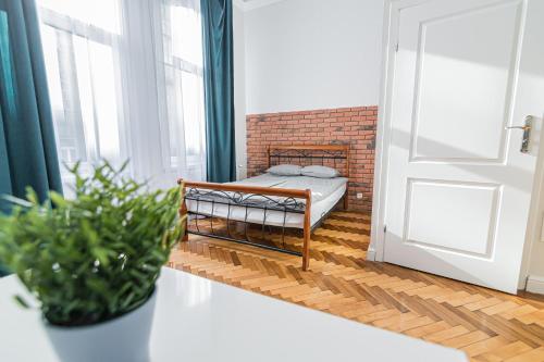 克拉科夫ROYAL Apartments的一间小卧室,配有床和砖墙
