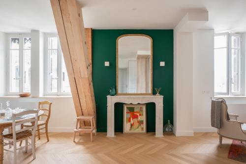 艾克斯莱班Les Suites du Bernascon - Appartement 4 étoiles的一间设有绿色墙壁和镜子的用餐室