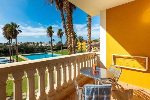 萨卡莱塔Vibra Blanc Palace Aparthotel的一个带桌椅的阳台和一个游泳池