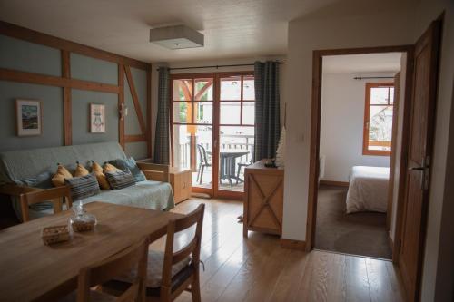 圣拉里苏朗Apparts au Cœur de St-Lary - Piscine Chauffée et Sauna的客厅配有沙发和桌子