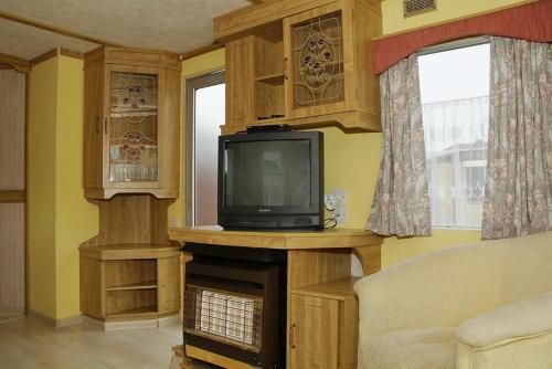 弗瓦迪斯瓦沃沃Camping Nadmorski的一间带电视和壁炉的客厅