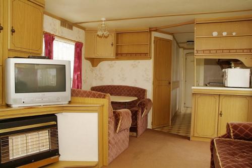 弗瓦迪斯瓦沃沃Camping Nadmorski的带电视的小型客厅和厨房
