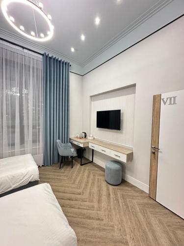 阿斯塔纳Five's Hotel Astana的配有书桌和电视的酒店客房
