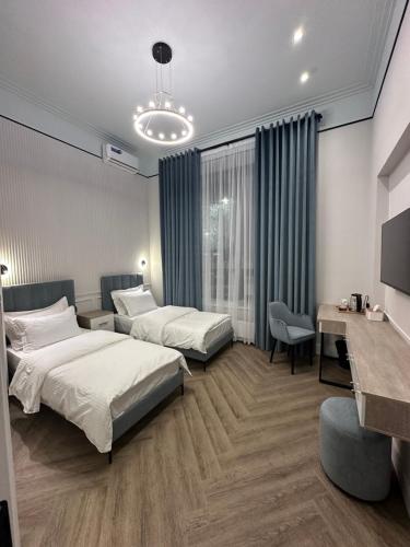 阿斯塔纳Five's Hotel Astana的酒店客房配有两张床和一张书桌