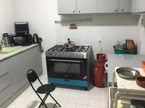 迪拜Dubai NorthStar Hostels的厨房配有炉灶和两把椅子