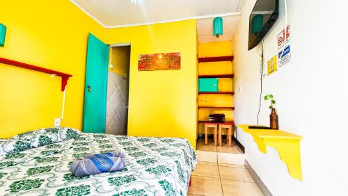 马塞约Proxima Estacion Hostel的一间卧室设有一张床和黄色的墙壁