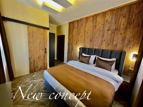 EdremitMiro Mara Boutique Hotel & Lounge Bar的一间卧室设有一张带木墙的大床