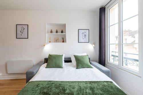 枫丹白露Cœur de Fontainebleau: Confort, Calme & Haut débit的白色卧室配有一张带绿色枕头的大床