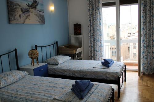 雅典Mona Hause的一间卧室设有两张单人床和一个窗户。