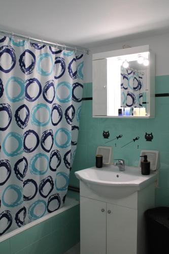 雅典Mona Hause的浴室设有水槽和蓝白色的浴帘