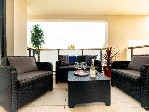 Le CrèsL'héliade - Climatisation et parking的客厅配有沙发和带酒杯的桌子