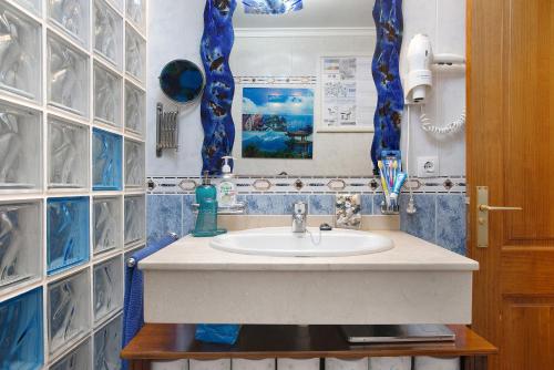 蒂纳霍Casa Lancelot的浴室配有水槽和蓝色瓷砖墙。