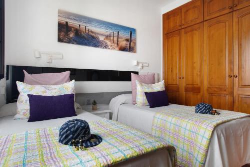 蒂纳霍Casa Lancelot的一间卧室设有两张床和木制橱柜