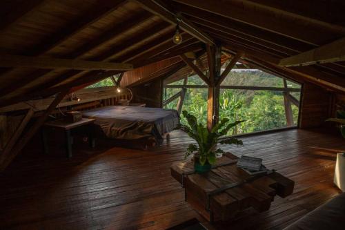 CaicedoniaBooHouse - A Wild Cabin in Colombia的一间卧室设有一张床和一个大窗户