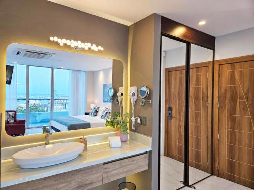 曼塔海菊蛤珍珠酒店的一间带水槽、床和镜子的浴室