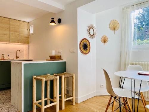 默东Appart 40m2 dans maison - Proche Paris的厨房配有桌椅和桌子。