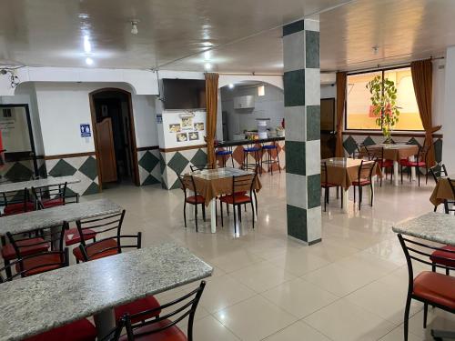 埃斯梅拉达斯Hotel Shekinah Internacional的一间带桌椅的餐厅和一间厨房