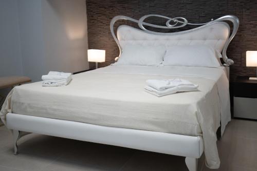 卡塔尼亚iitana Luxury Apartment - Catania Fronte Mare的客房内的白色床和2条毛巾