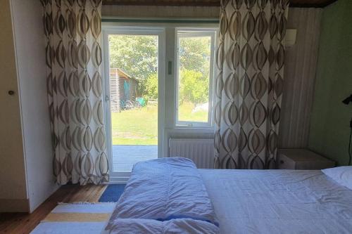 福勒Gästhus på Fårös savann.的一间卧室设有一张床和一个大窗户