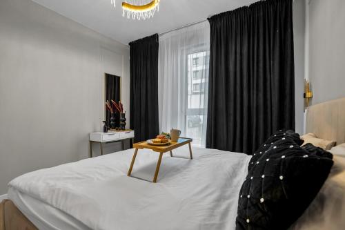 华沙Airport Apartment - Private Terrace & Parking - by Rentujemy的一间卧室配有一张桌子和一张床铺