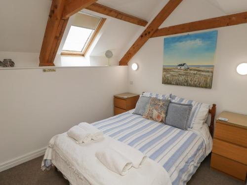 锡豪西斯The Boathouse Seahouses的卧室配有一张床,墙上挂有一幅马术画