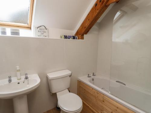 锡豪西斯The Boathouse Seahouses的浴室配有卫生间、盥洗盆和浴缸。