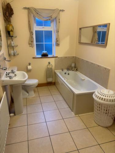 DurrusTilly's Cottage的带浴缸、卫生间和盥洗盆的浴室