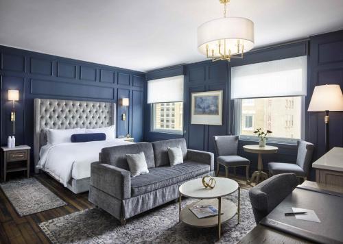 旧金山Beacon Grand, A Union Square Hotel的卧室拥有蓝色的墙壁,配有一张床和一张沙发