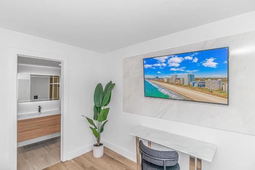 默特尔比奇Fifth and Ocean的白色的房间,配有桌子和墙上的电视