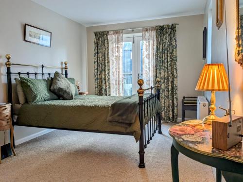 特维德上游的贝里克18 Mill Wharf Apartment的一间卧室设有一张床、一个窗口和一张桌子