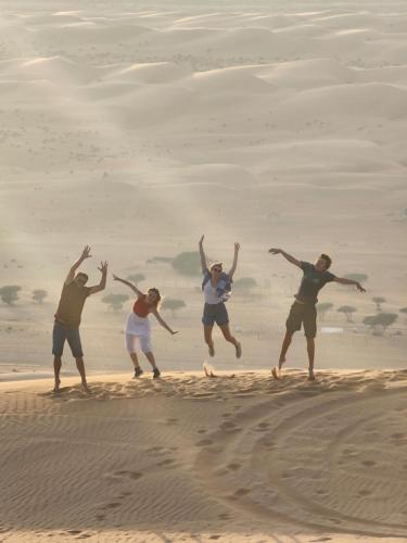 Al WāşilBubbles Domes Private Cmp的一群人跳进沙子里