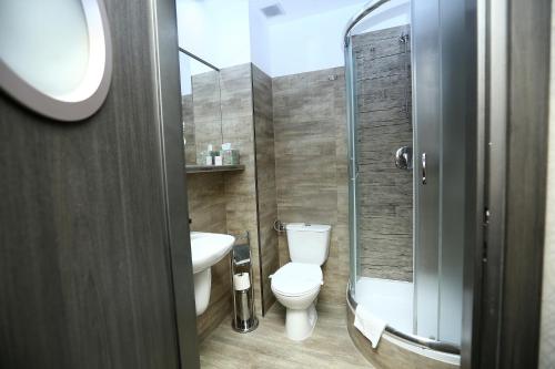 皮拉福马酒店的一间带卫生间和玻璃淋浴间的浴室