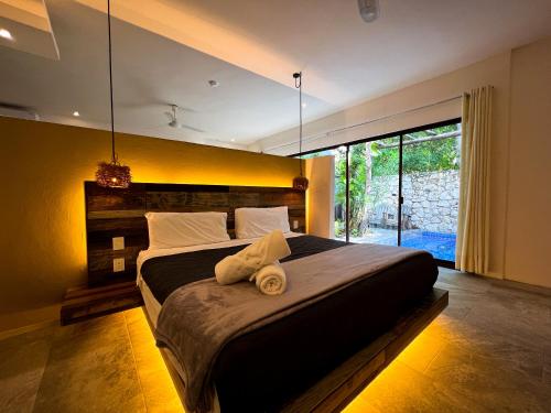 图卢姆Kuun Taak Tulum的一间卧室设有一张大床和大窗户