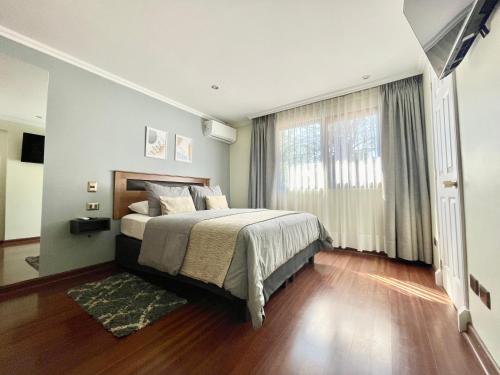圣地亚哥Olea's Home Las Condes的一间卧室设有一张床和一个大窗户