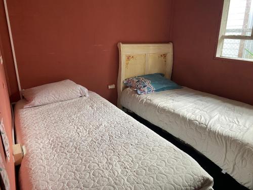 柴滕La cabaña的配有红色墙壁的小客房内的两张床