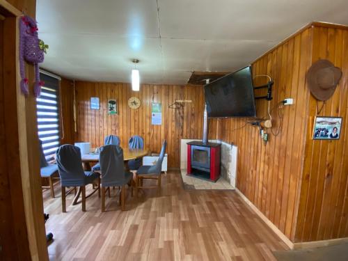 柴滕La cabaña的一间带桌椅和电视的用餐室