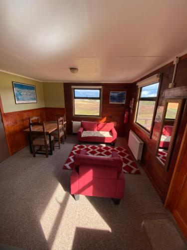 百内三塔廷德尔湖山林小屋的客厅配有红色的沙发和桌子