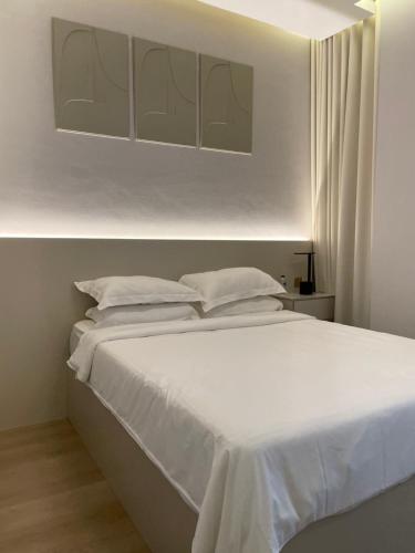 沙迦1 BR Luxury Apt by AJ Aljada的白色的床、白色床单和枕头