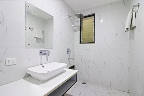新德里Hotel Bellwood Grand Near Delhi IGI Airport的白色的浴室设有水槽和镜子