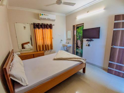 曼德维HK Inn的一间卧室配有一张床和镜子