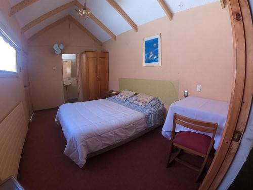 洛斯安赫莱斯Hotel Sol de Alicante的一间小卧室,配有两张床和椅子