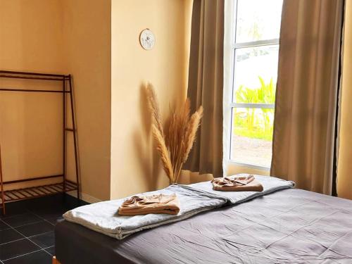 Ban NuaVilla Wonderworld Resort的窗户和2条毛巾的客房内的一张床
