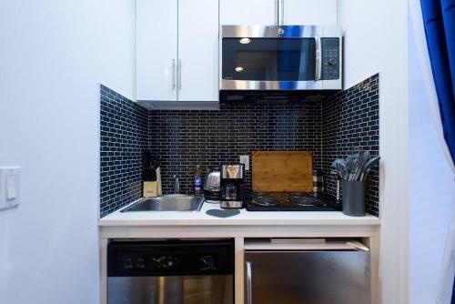 纽约69-4B Modern Lower East Side 1BR PRIME LOCATION的厨房配有水槽和微波炉