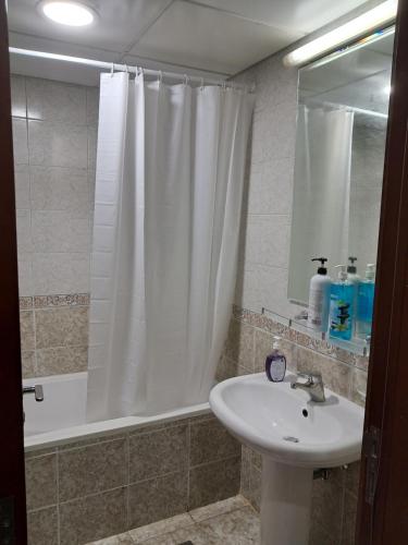 阿布扎比Top House Hostel的一间带水槽和淋浴帘的浴室