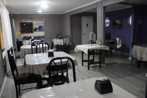 科伊艾科HOTEL LOYOLA的一间带桌椅的用餐室和一间带紫色墙壁的房间