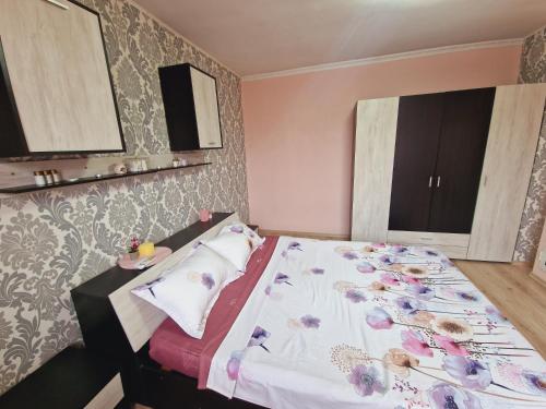 索非亚Bellaroom Sofia airport的一间卧室配有一张带花卉图案墙壁的床