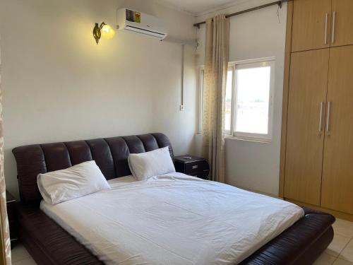 阿克拉AGASTEV Guesthouse GH的卧室内一张带皮革床头板的床
