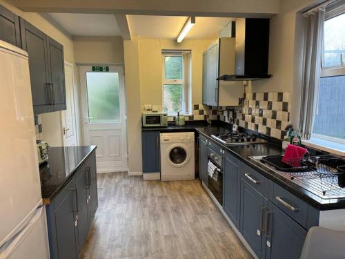 LongleyHome in Sheffield with King/Twin bed的厨房配有蓝色橱柜和洗衣机。