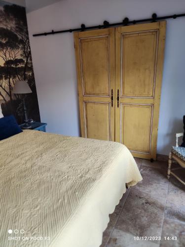 索尔格河畔利勒LE PETIT JARDIN ...的一间卧室配有一张床和一个木制橱柜