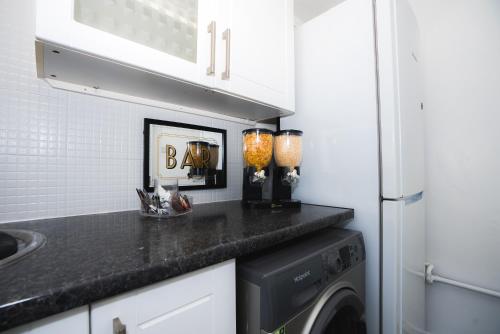 伦敦1 Bed Flat Tottenham Hale N17的厨房配有洗衣机和烘干机